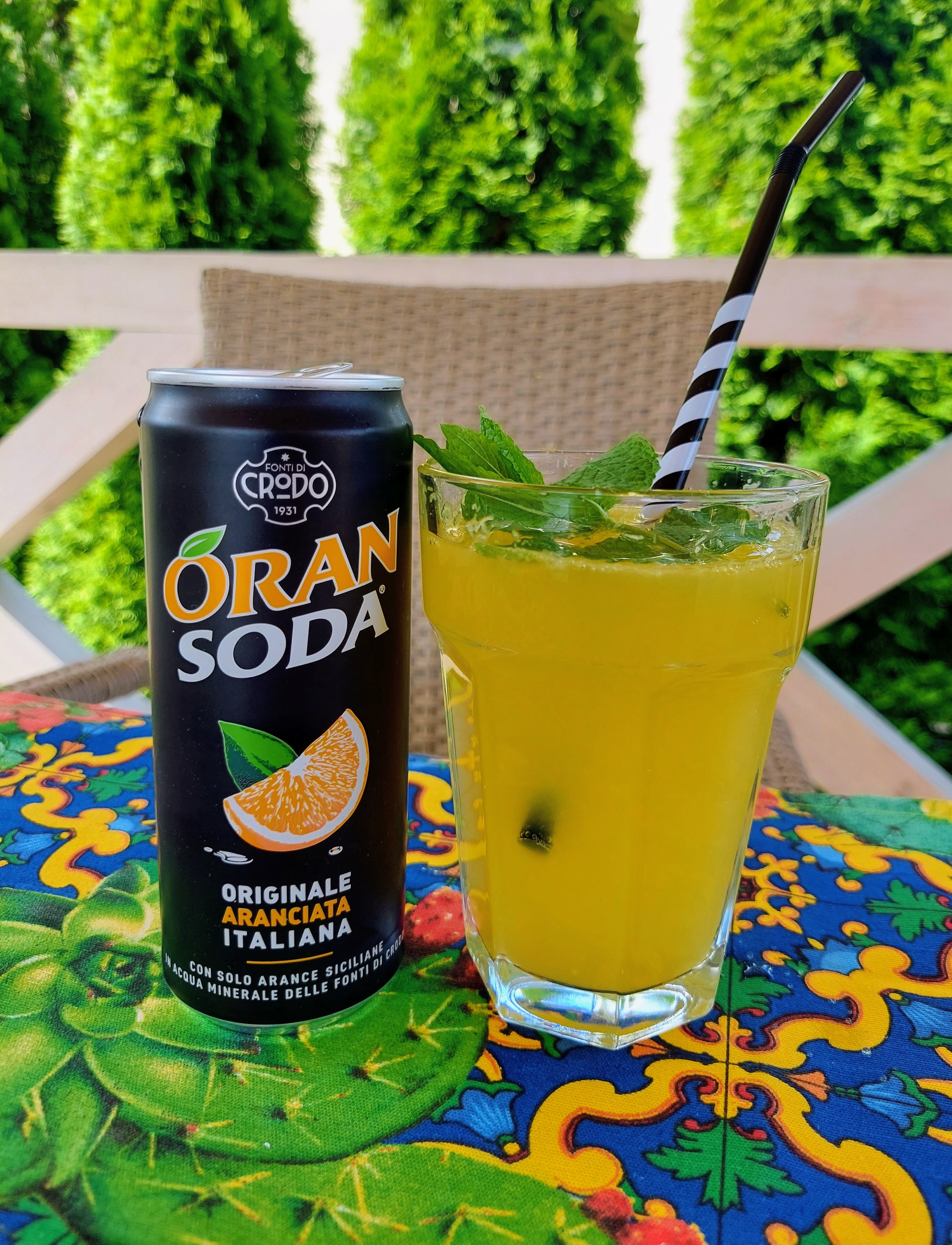 Przelany napój Oran Soda do szklanki, stojący obok jego puszki.